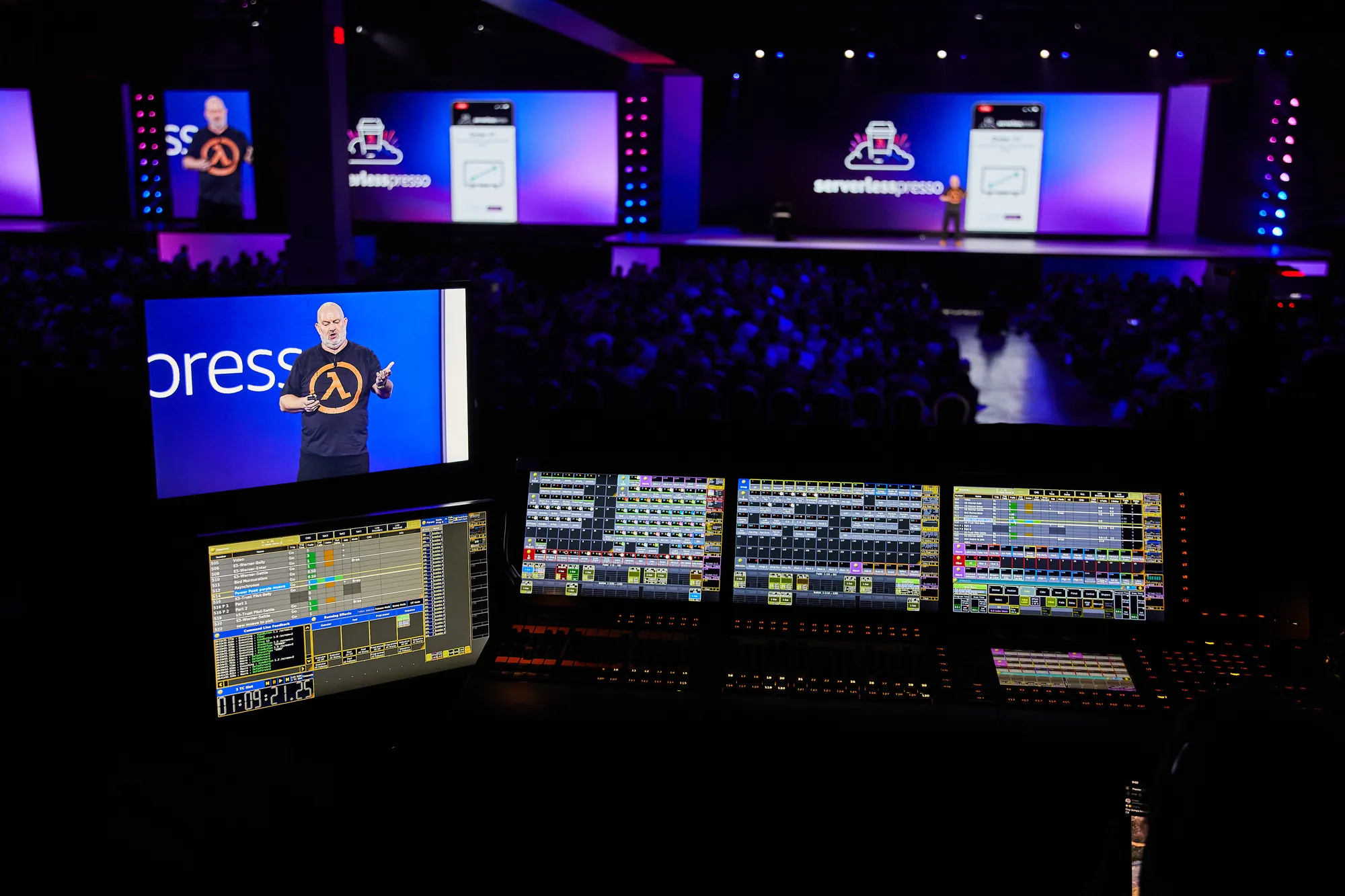 Front of house: the vision mixer's monitors glowing in the dark below the stage